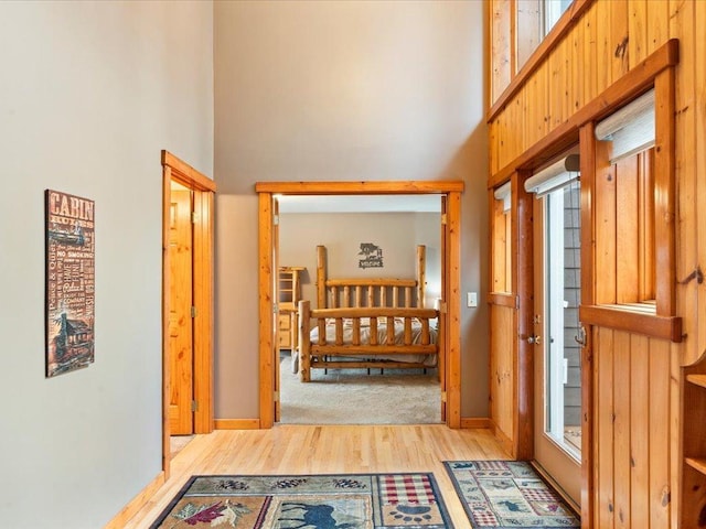 hallway featuring a high ceiling and light hardwood / wood-style floors