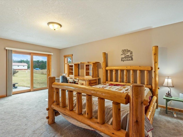 carpeted bedroom featuring access to exterior and a textured ceiling