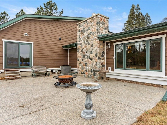 rear view of house with an outdoor fire pit and a patio