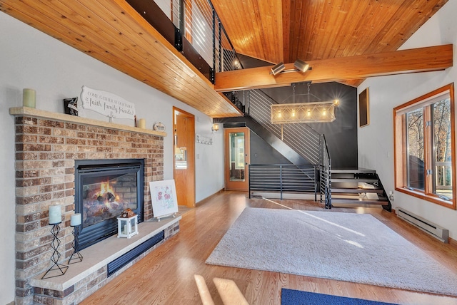 16568 Maplewood Rd, Wakefield Twp, MN 56320 - living area featuring a baseboard radiator, wood finished floors, stairway, a fireplace, and wooden ceiling