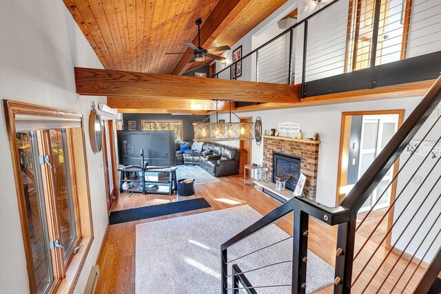 living room with a brick fireplace, wooden ceiling, high vaulted ceiling, ceiling fan, and light wood-type flooring