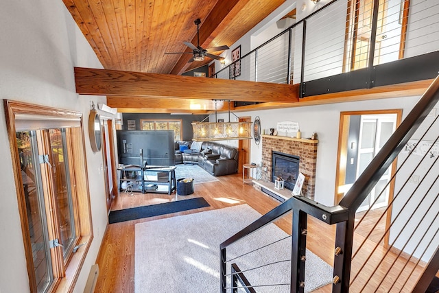 16568 Maplewood Rd, Wakefield Twp, MN 56320 - living room featuring wood ceiling, ceiling fan, wood finished floors, stairway, and a brick fireplace