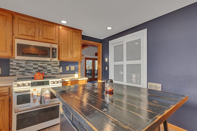 16568 Maplewood Rd, Wakefield Twp, MN 56320 - kitchen with stainless steel appliances, decorative backsplash, recessed lighting, french doors, and brown cabinetry
