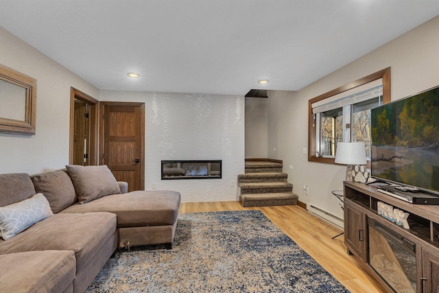16568 Maplewood Rd, Wakefield Twp, MN 56320 - living room featuring light wood-type flooring, a fireplace, a baseboard heating unit, recessed lighting, and baseboards