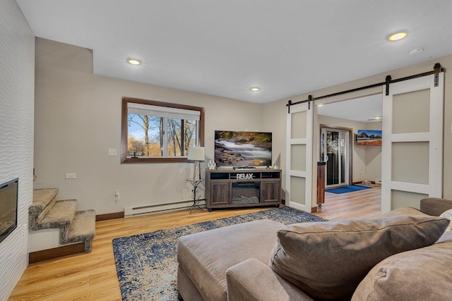 16568 Maplewood Rd, Wakefield Twp, MN 56320 - living area with a barn door, baseboard heating, wood finished floors, baseboards, and recessed lighting