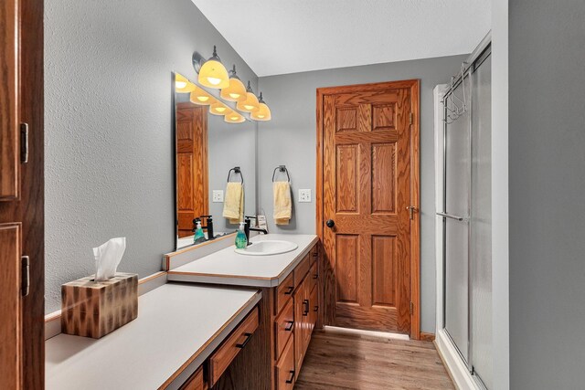 bathroom featuring vanity, hardwood / wood-style flooring, and a shower with door