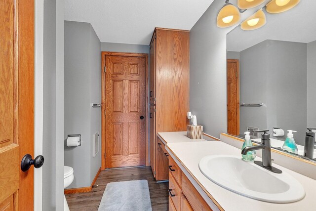 bathroom featuring hardwood / wood-style flooring, vanity, and toilet