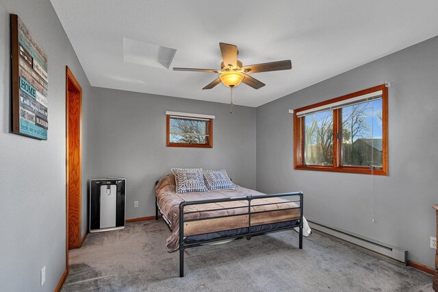 bedroom with baseboard heating, carpet flooring, and ceiling fan