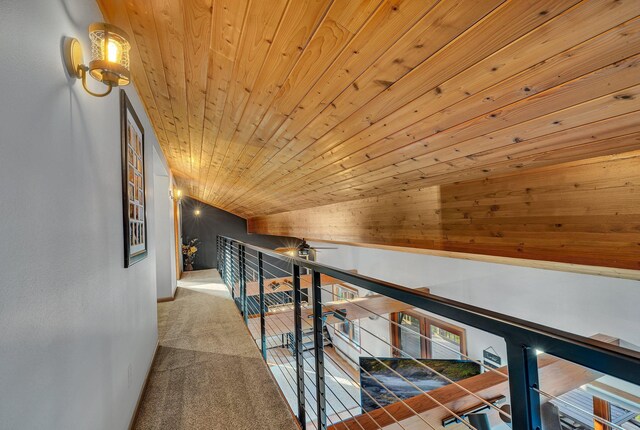 hallway featuring wooden ceiling, carpet flooring, and vaulted ceiling