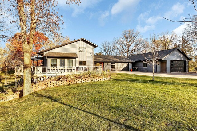 single story home with a garage, a front yard, and a deck