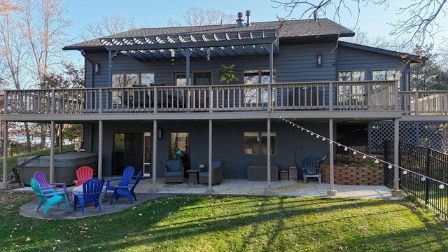 back of house featuring a hot tub, a wooden deck, a patio, and a yard