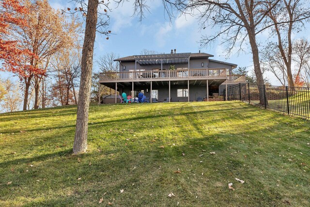 rear view of property with a wooden deck and a yard