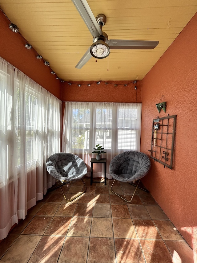 sunroom / solarium featuring ceiling fan and wooden ceiling