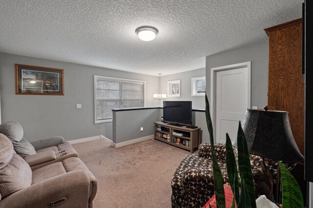 carpeted living room featuring a notable chandelier and a textured ceiling