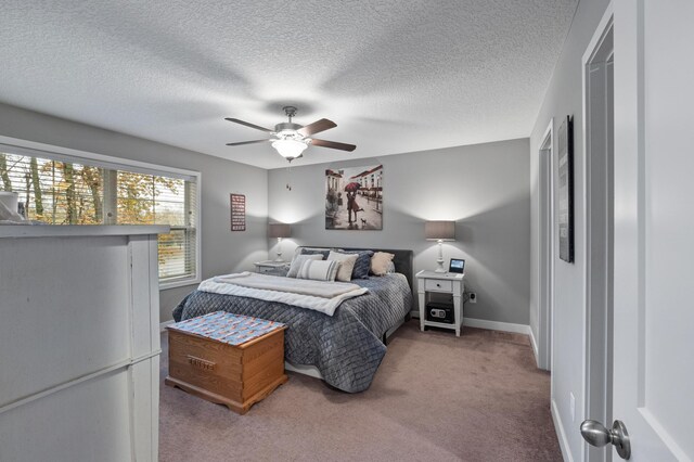 bedroom featuring ceiling fan, a textured ceiling, and carpet floors