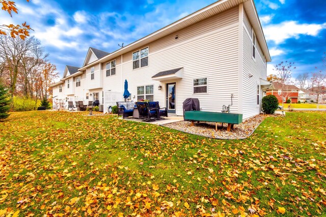 rear view of house featuring a yard and a patio area