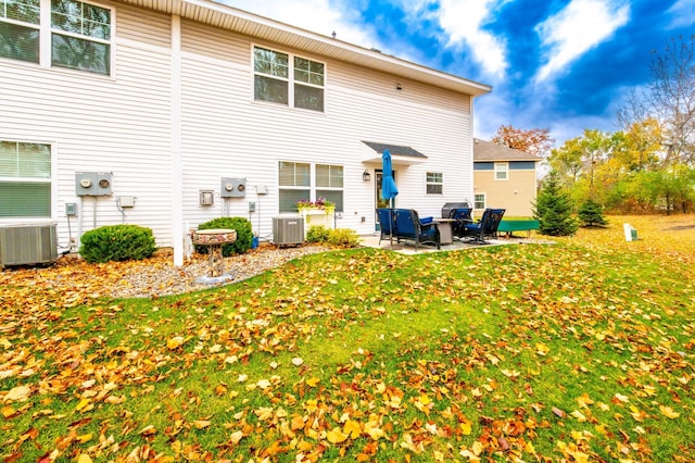 rear view of house featuring a yard, cooling unit, and a patio area