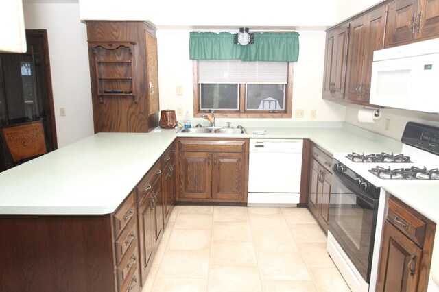 kitchen with kitchen peninsula, sink, white appliances, and light tile patterned flooring