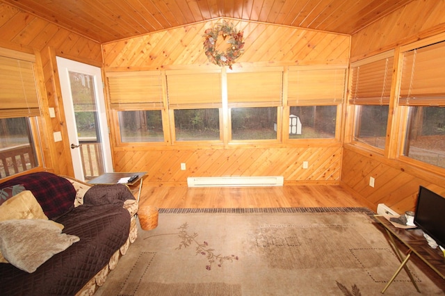 interior space featuring wood walls, a baseboard heating unit, lofted ceiling, and wooden ceiling