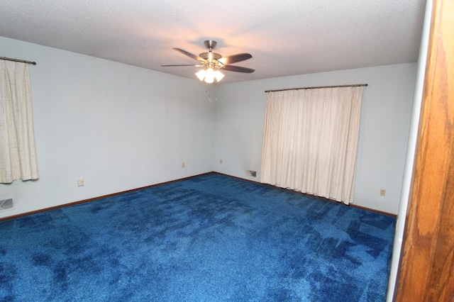 unfurnished bedroom with a textured ceiling, dark colored carpet, and ceiling fan