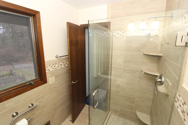 bathroom featuring an enclosed shower and tile walls