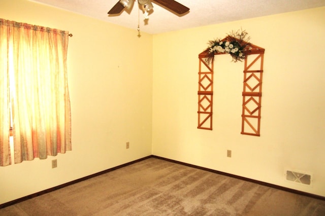 empty room featuring a textured ceiling, carpet floors, and ceiling fan