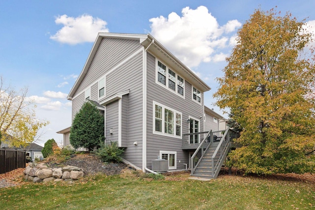 back of house featuring a yard, central AC, and a wooden deck