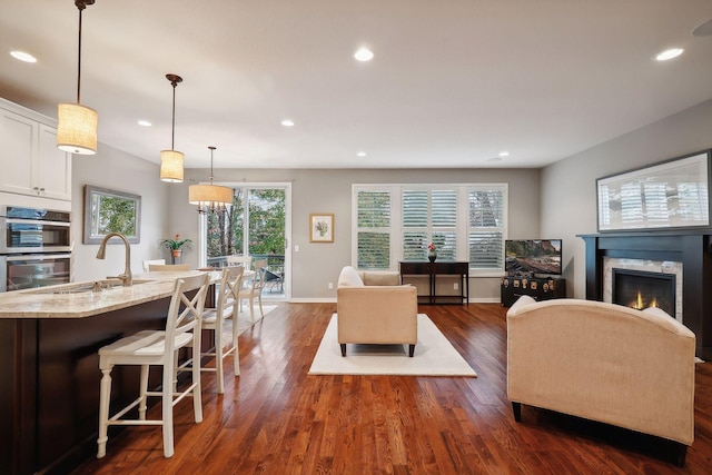 living room featuring sink, dark hardwood / wood-style floors, and a chandelier