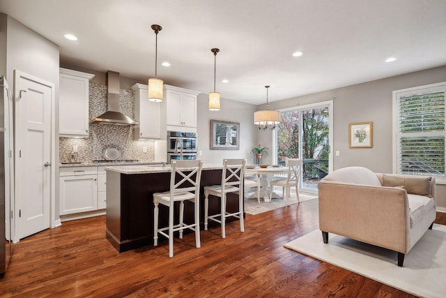 kitchen featuring wall chimney exhaust hood, white cabinets, and dark hardwood / wood-style flooring