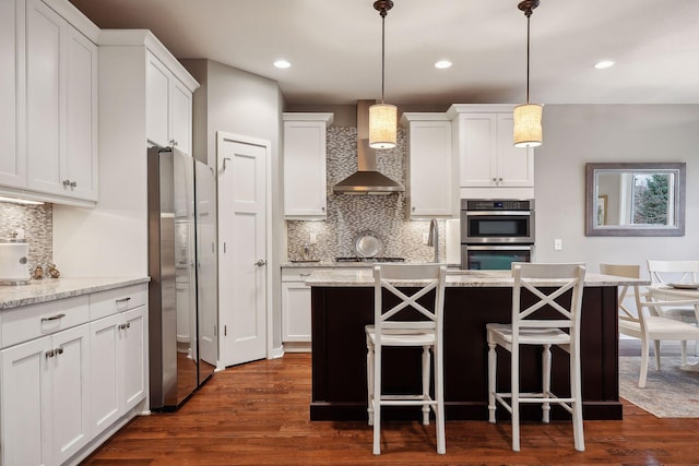 kitchen featuring stainless steel appliances, light stone countertops, dark hardwood / wood-style floors, and white cabinets