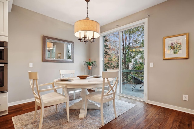 dining space with a notable chandelier and dark hardwood / wood-style floors