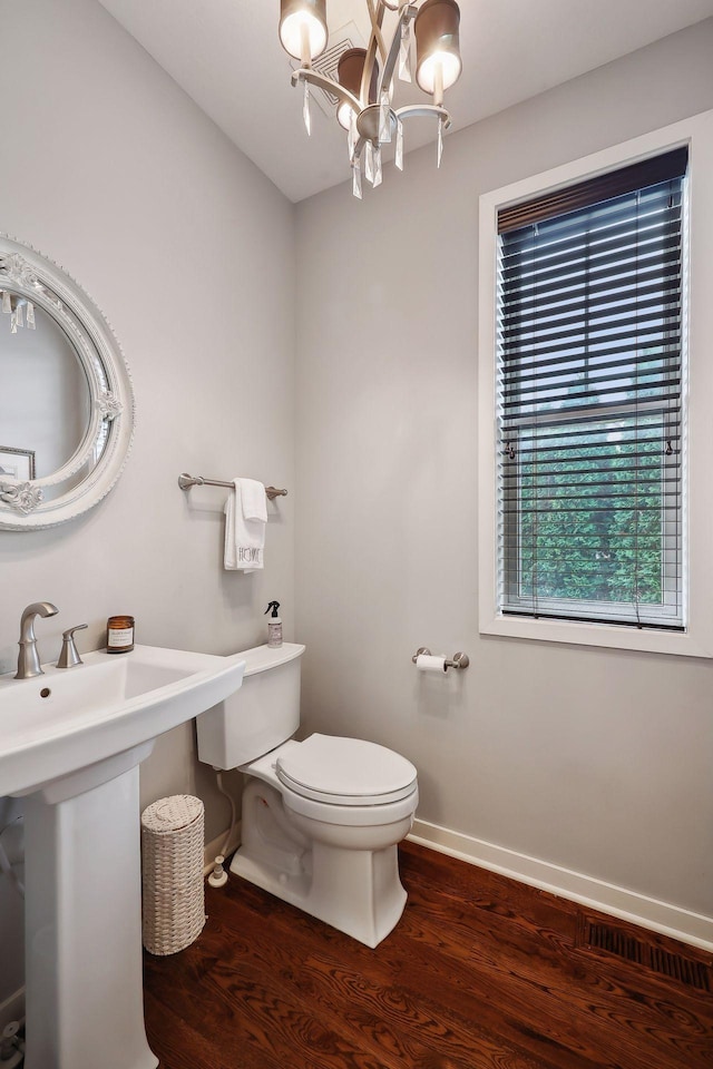 bathroom with toilet, sink, a chandelier, and hardwood / wood-style floors