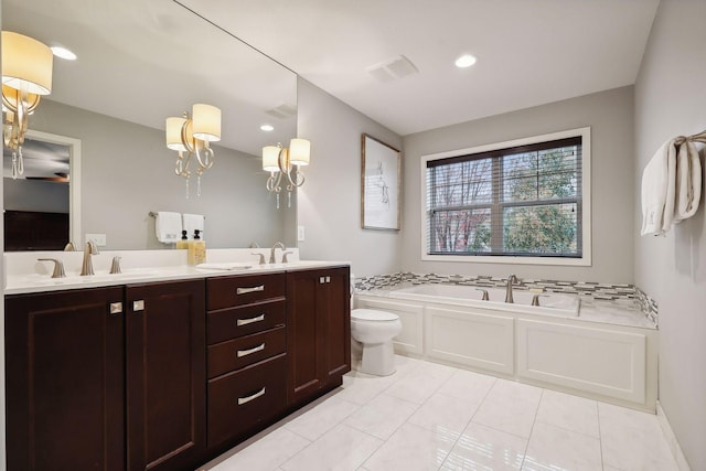 bathroom with vanity, a tub to relax in, toilet, and tile patterned flooring