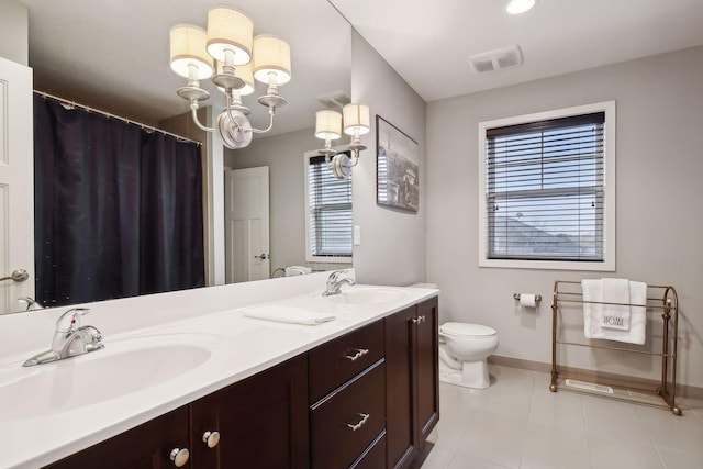 bathroom with an inviting chandelier, vanity, toilet, and tile patterned floors