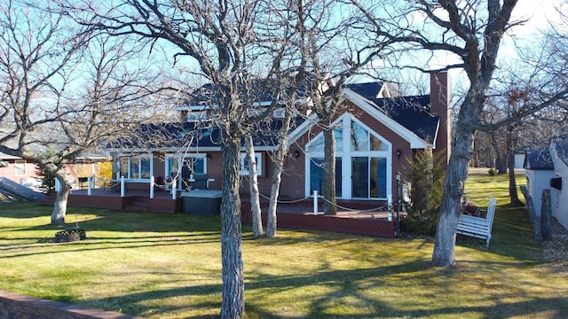 view of front facade with a wooden deck and a front lawn