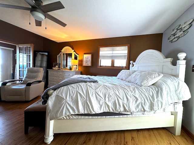 bedroom featuring ceiling fan, wood-type flooring, and lofted ceiling