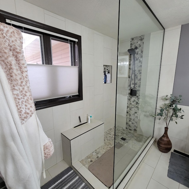 bathroom featuring tiled shower, tile patterned floors, and tile walls