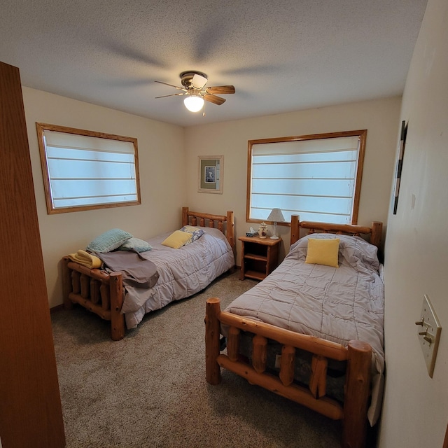 bedroom featuring carpet flooring, a textured ceiling, multiple windows, and ceiling fan