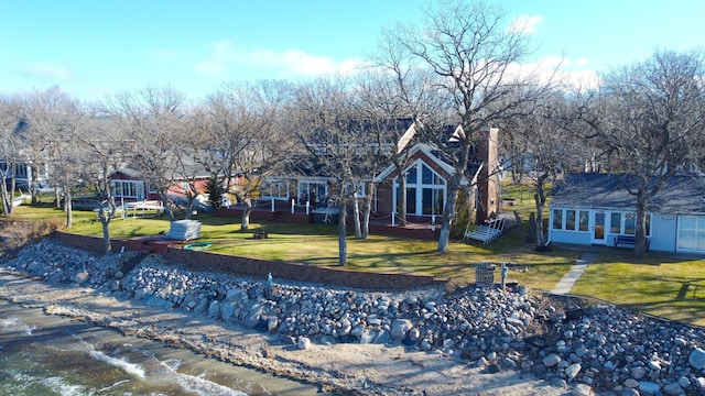 view of front of house featuring a sunroom and a front lawn