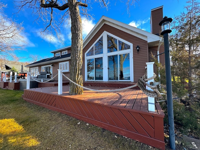 rear view of house with a deck and a yard