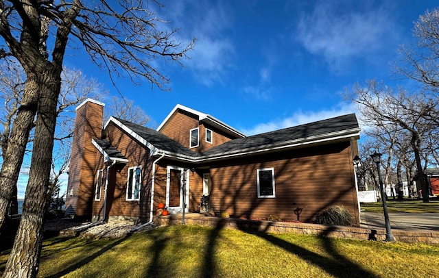 view of front facade featuring a chimney and a front yard