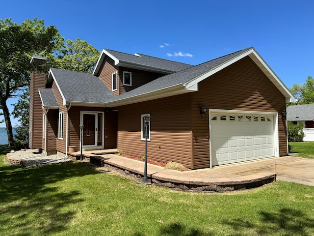 145 Bay View Rd, Ottertail, MN 56571 - view of side of home with an attached garage, a chimney, roof with shingles, concrete driveway, and a lawn