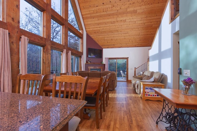 dining room with a healthy amount of sunlight, hardwood / wood-style floors, high vaulted ceiling, and wooden ceiling