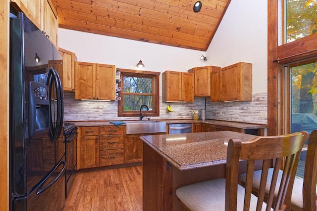 kitchen with sink, black appliances, a wealth of natural light, and wooden ceiling