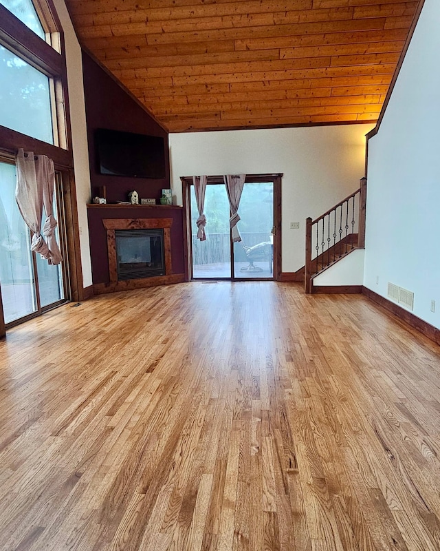 unfurnished living room featuring high vaulted ceiling, light wood-type flooring, and wooden ceiling