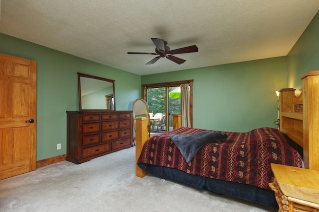 carpeted bedroom featuring access to outside, a textured ceiling, and ceiling fan