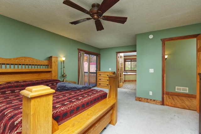 carpeted bedroom with ceiling fan and a textured ceiling