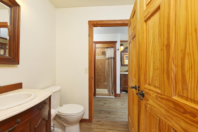 bathroom with vanity, hardwood / wood-style flooring, toilet, and walk in shower