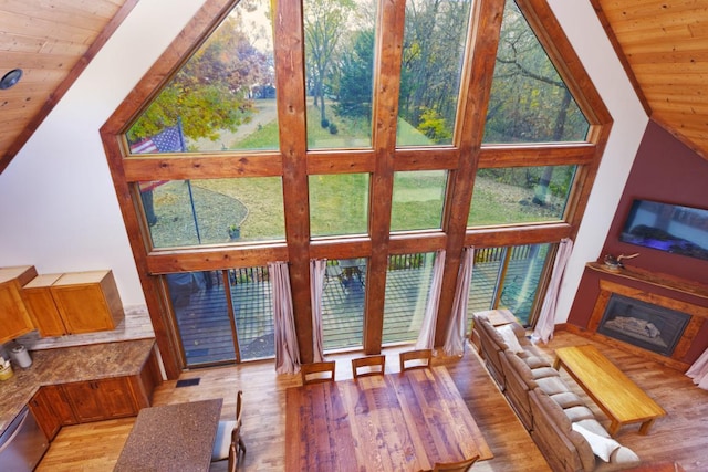 living room featuring light hardwood / wood-style floors, wood ceiling, and high vaulted ceiling