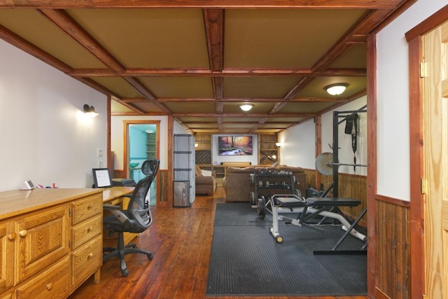 workout room featuring wood walls, coffered ceiling, and dark hardwood / wood-style flooring